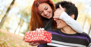 Woman surprising man with a gift