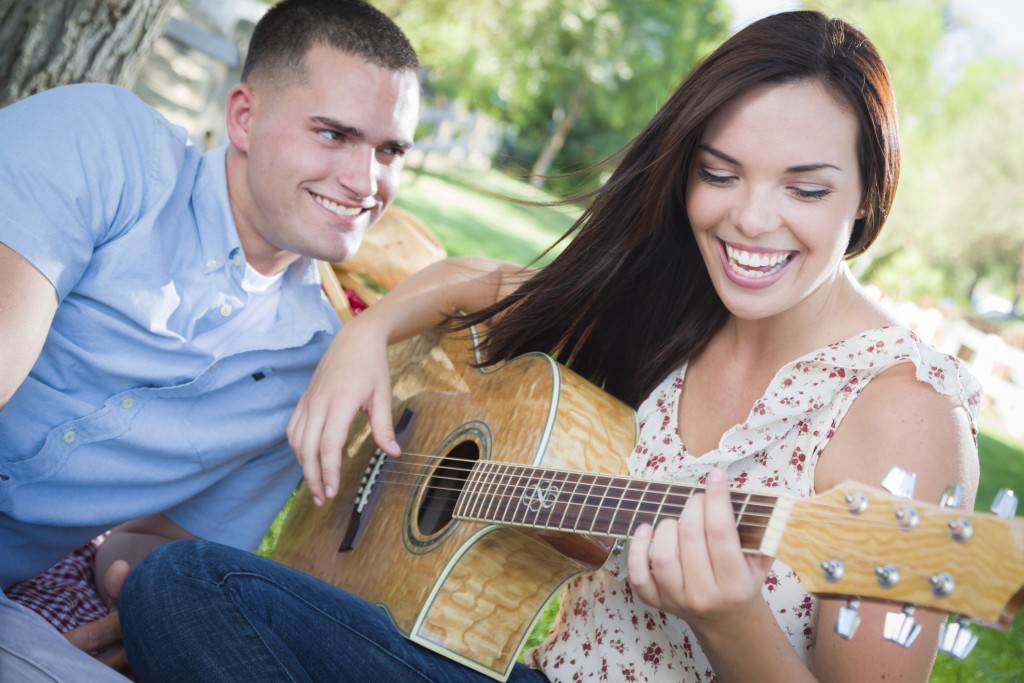 Happy woman playing guitar
