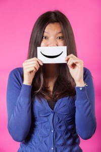 Woman holding smiling emoticon