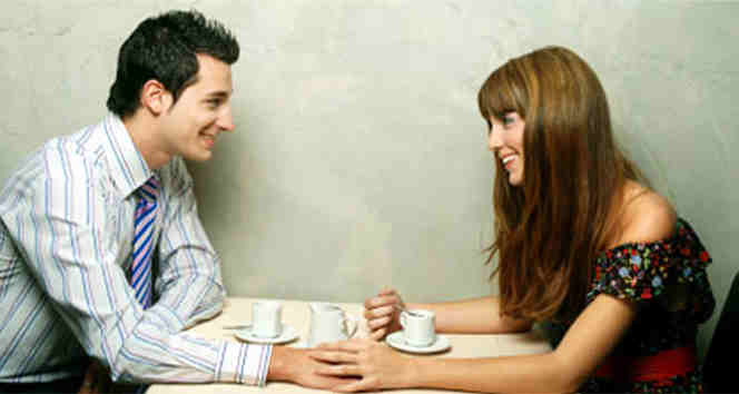 Couple touching and drinking coffee