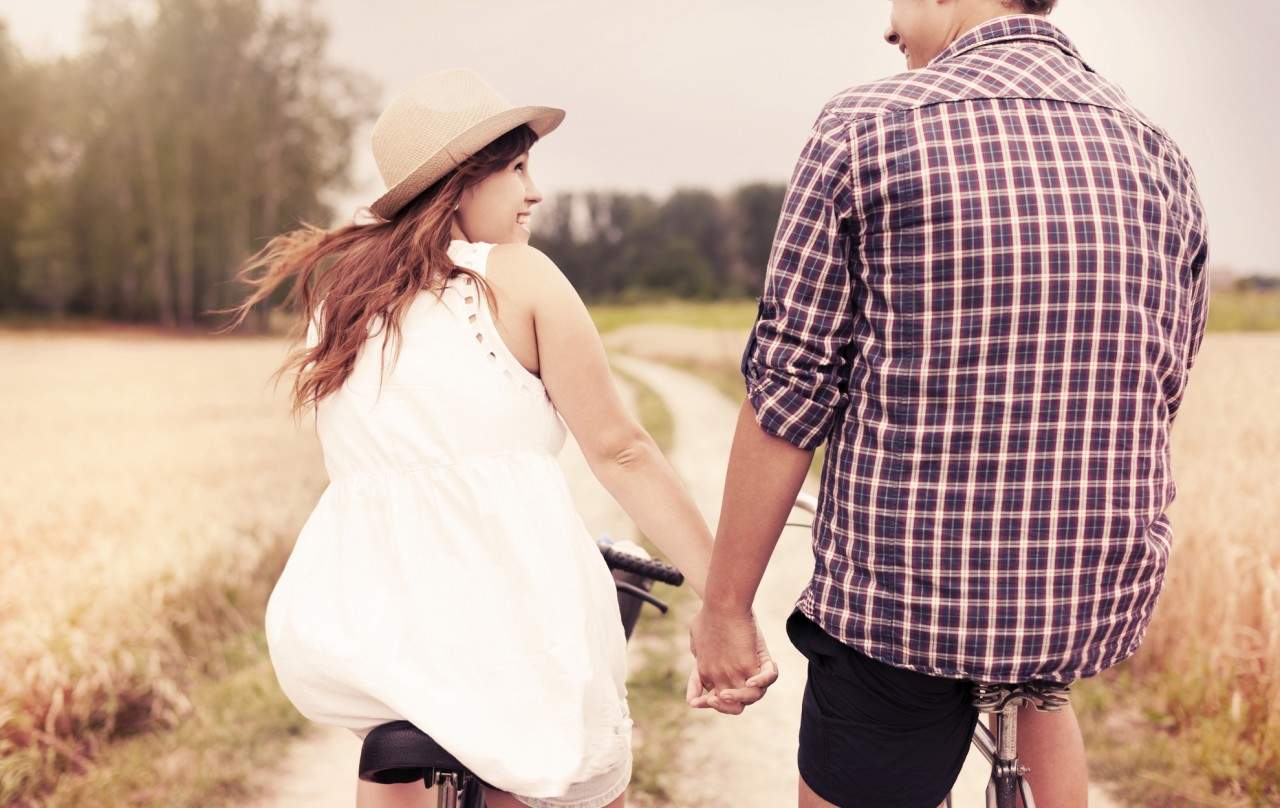 couple holding hands on a bike ride 